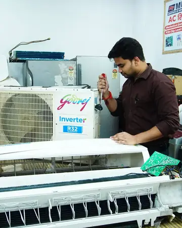 A technician servicing an air conditioning unit